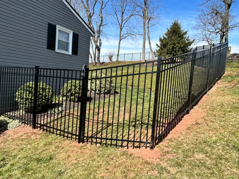 Black aluminum fence installed around a residential house.